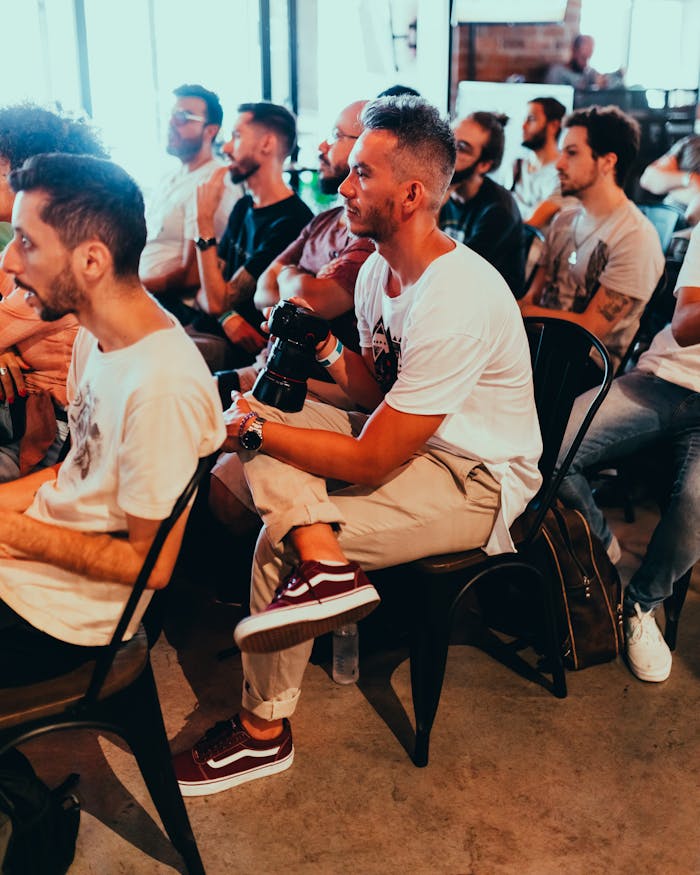 A group of adults attentively listening at an indoor seminar or conference.
